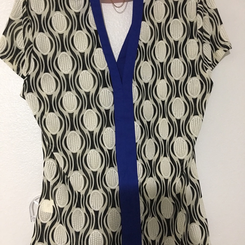 A blue gray and black blouse and blue pants